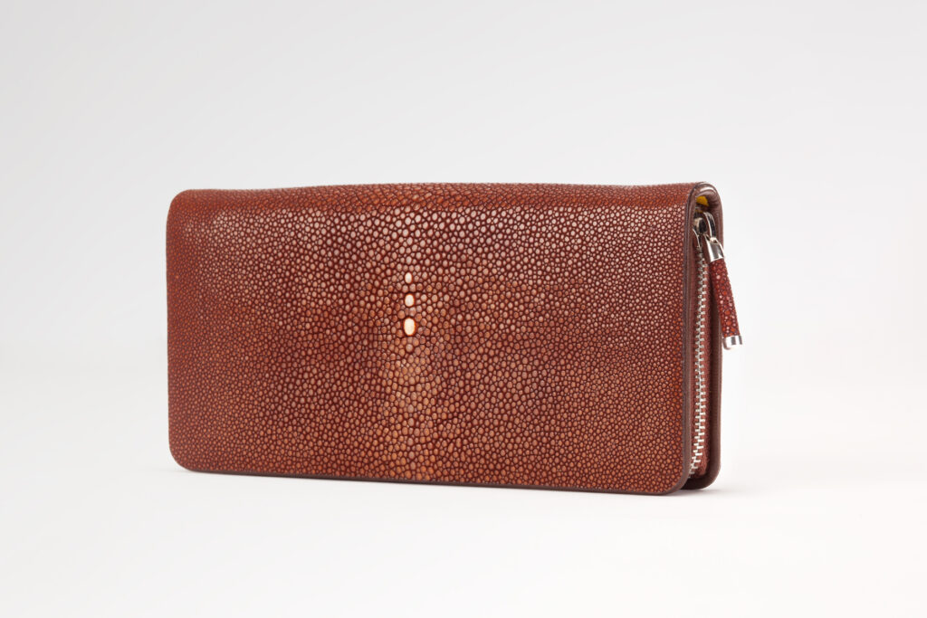 Brown stingray leather zip-around wallet by AKNAS featuring a textured finish and silver zipper closure.