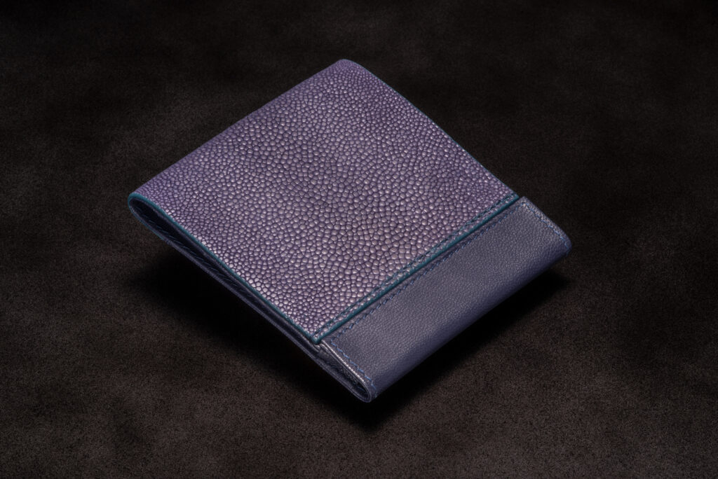 Purple stingray leather bifold wallet by AKNAS featuring a textured finish, smooth leather trim and slim design.