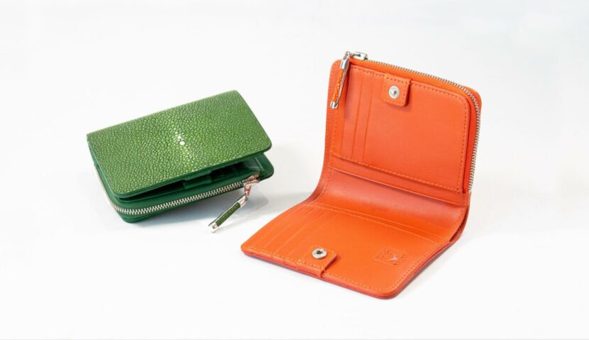 Green stingray leather wallet with textured finish and orange leather wallet showing interior card slots and zippered compartments from AKNAS